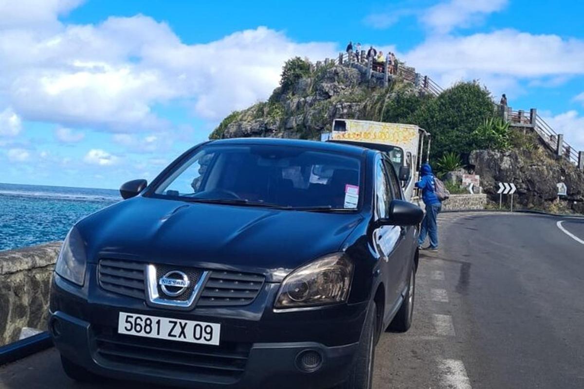 um carro estacionado na beira de uma estrada perto do oceano