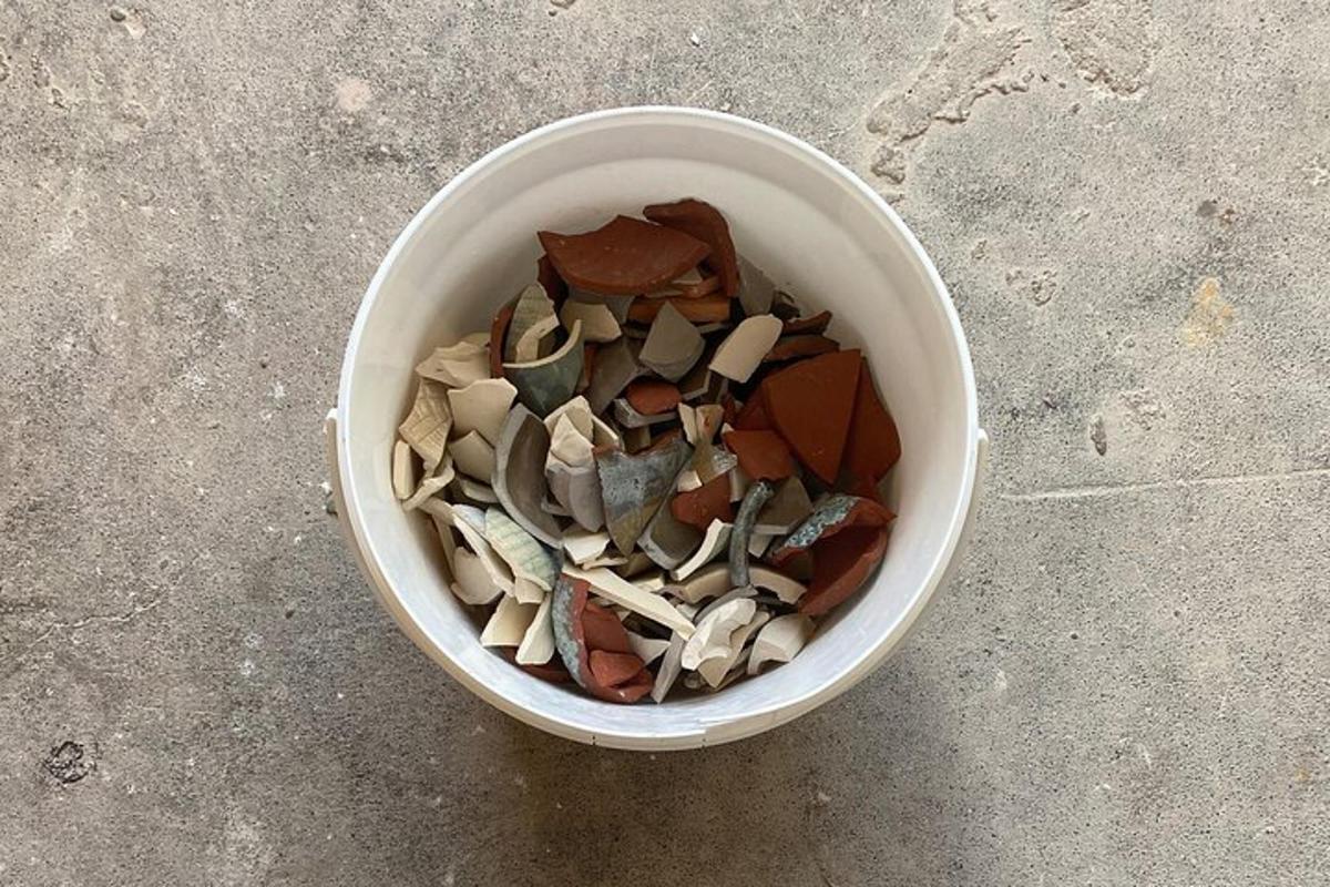 Un cubo blanco lleno de diferentes tipos de rocas.