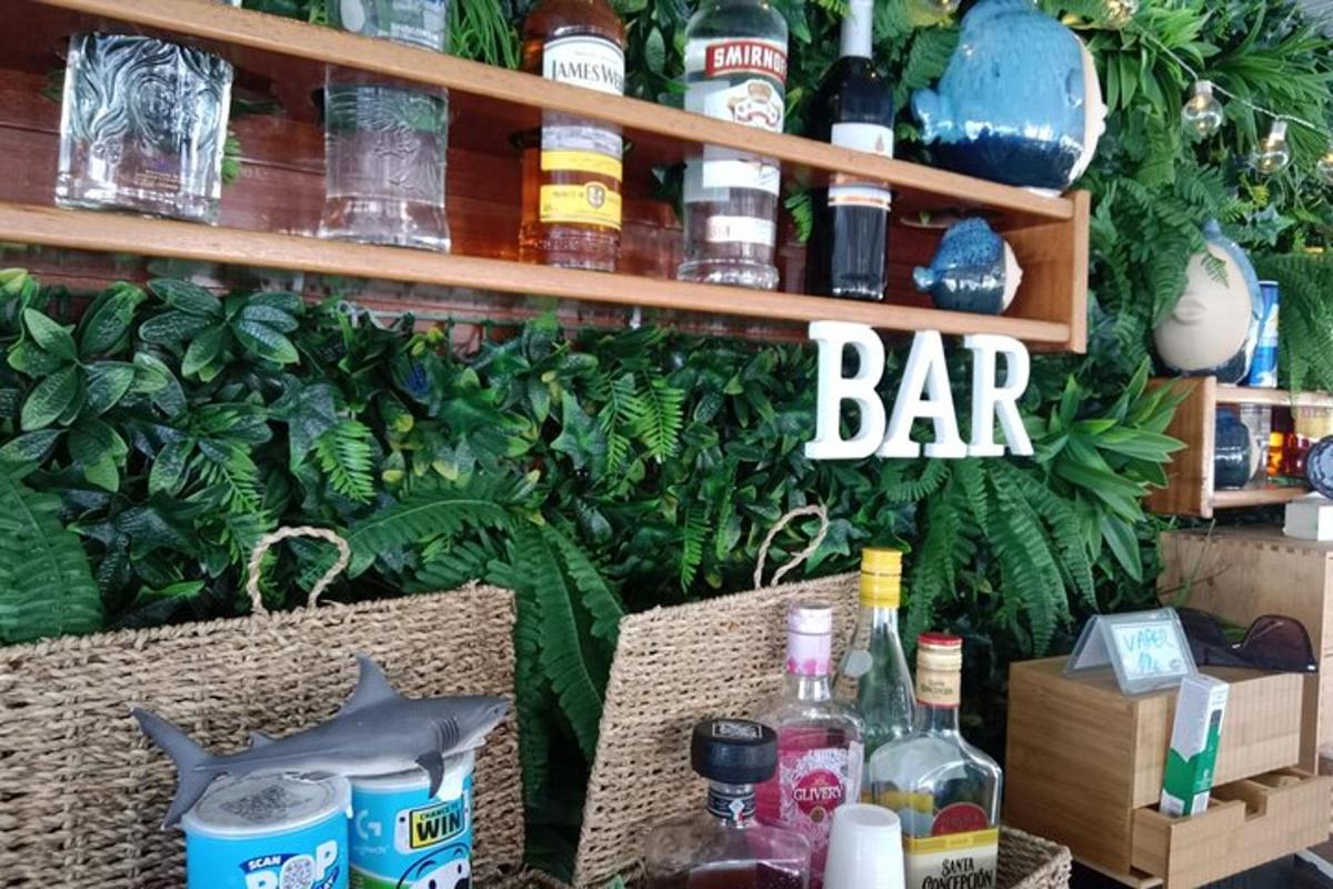 barová cedule na zdi s lahvemi alkoholu