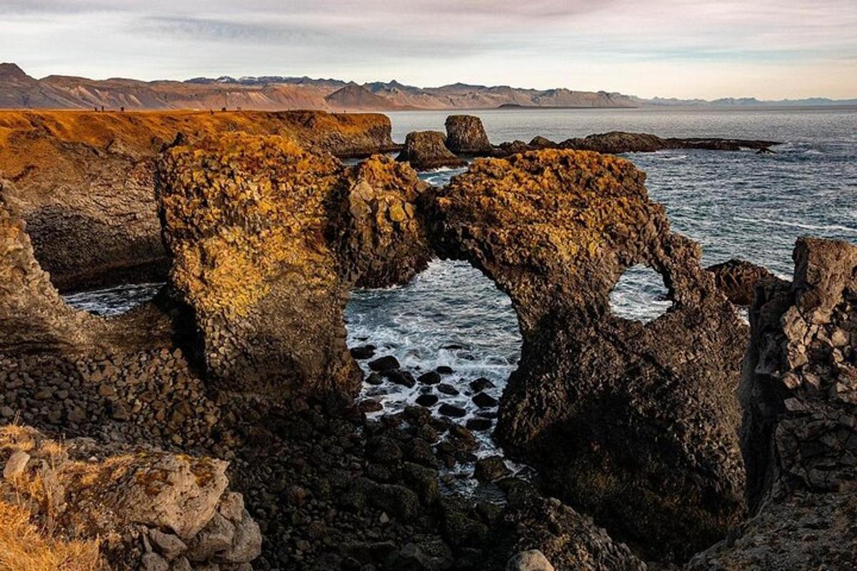 a group of rocks on the shore of the ocean