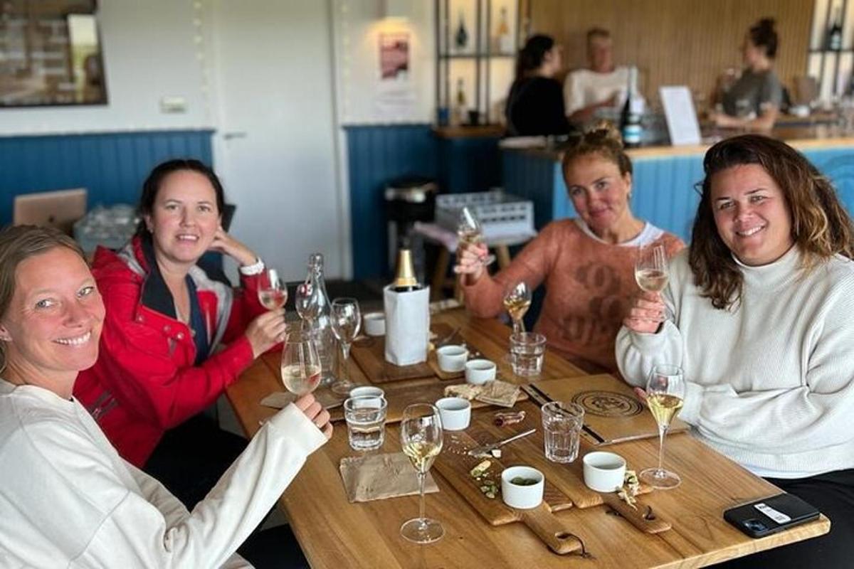 un gruppo di donne sedute attorno a un tavolo con bicchieri di vino