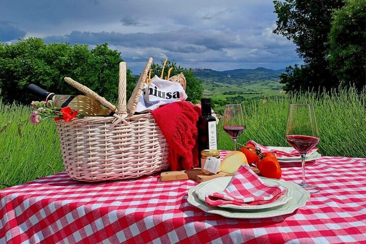 a picnic table with a basket of food and wine