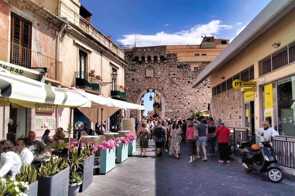 a crowd of people walking down a street near a building