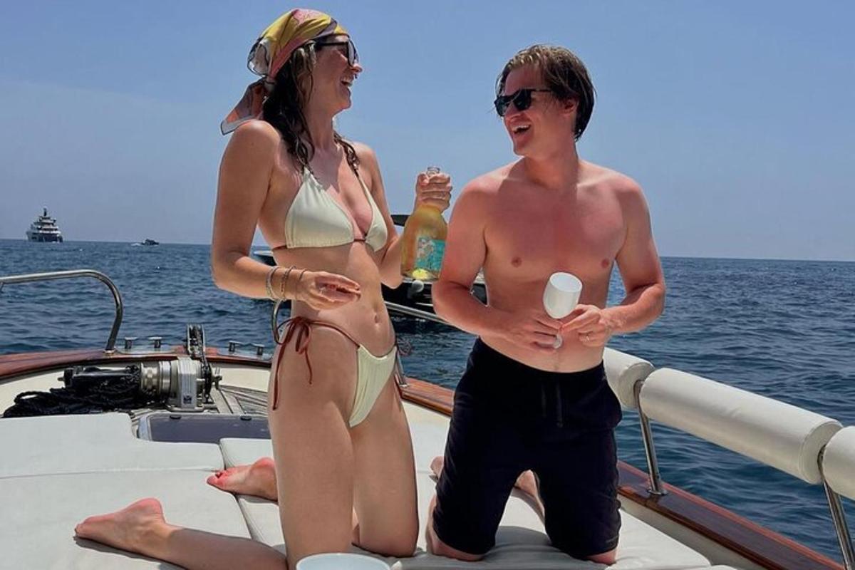 dve osebi v bikinijih, ki stojita na čolnu