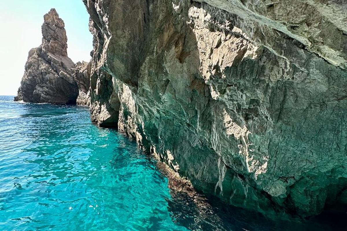 skalna pečina ob oceanu z modro vodo