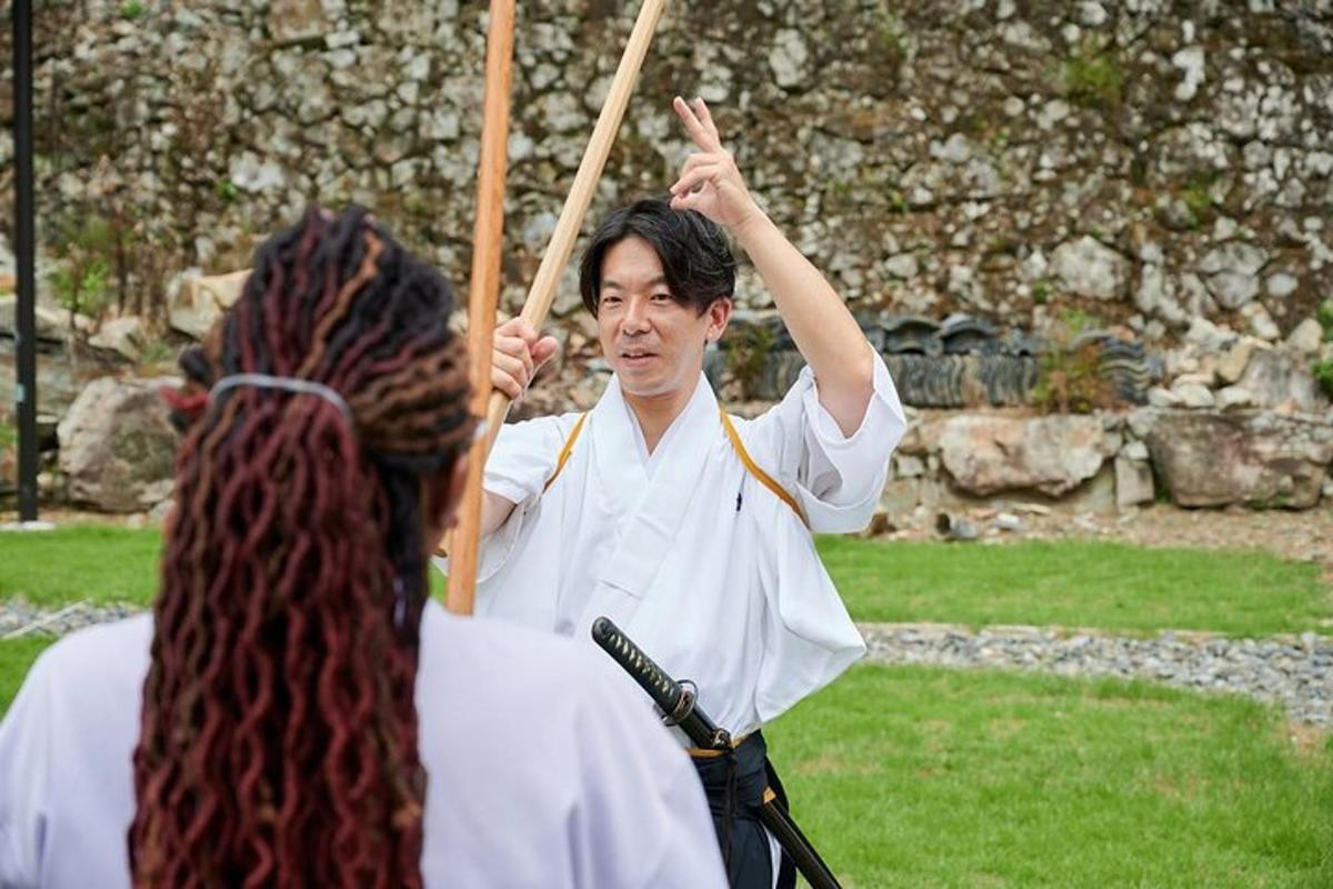 a man in white uniform holding two wooden sticks
