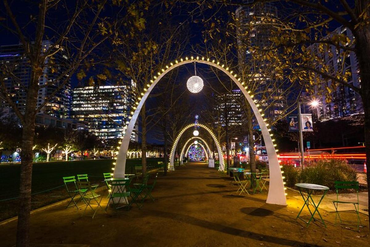 สวนสาธารณะที่มีซุ้มประตูพร้อมไฟส่องสว่างในตอนกลางคืน