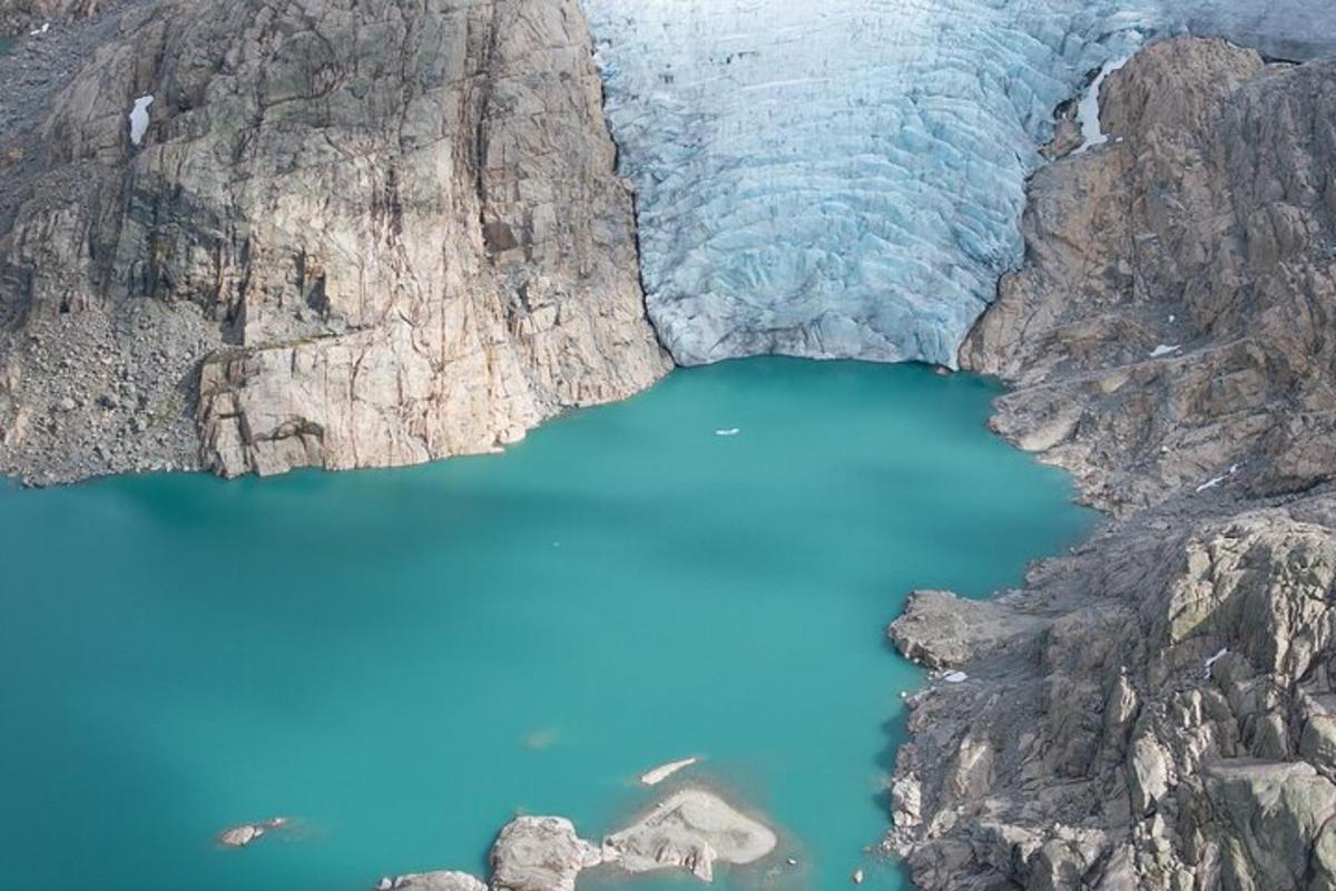 Una vista aérea de un lago azul entre dos montañas.