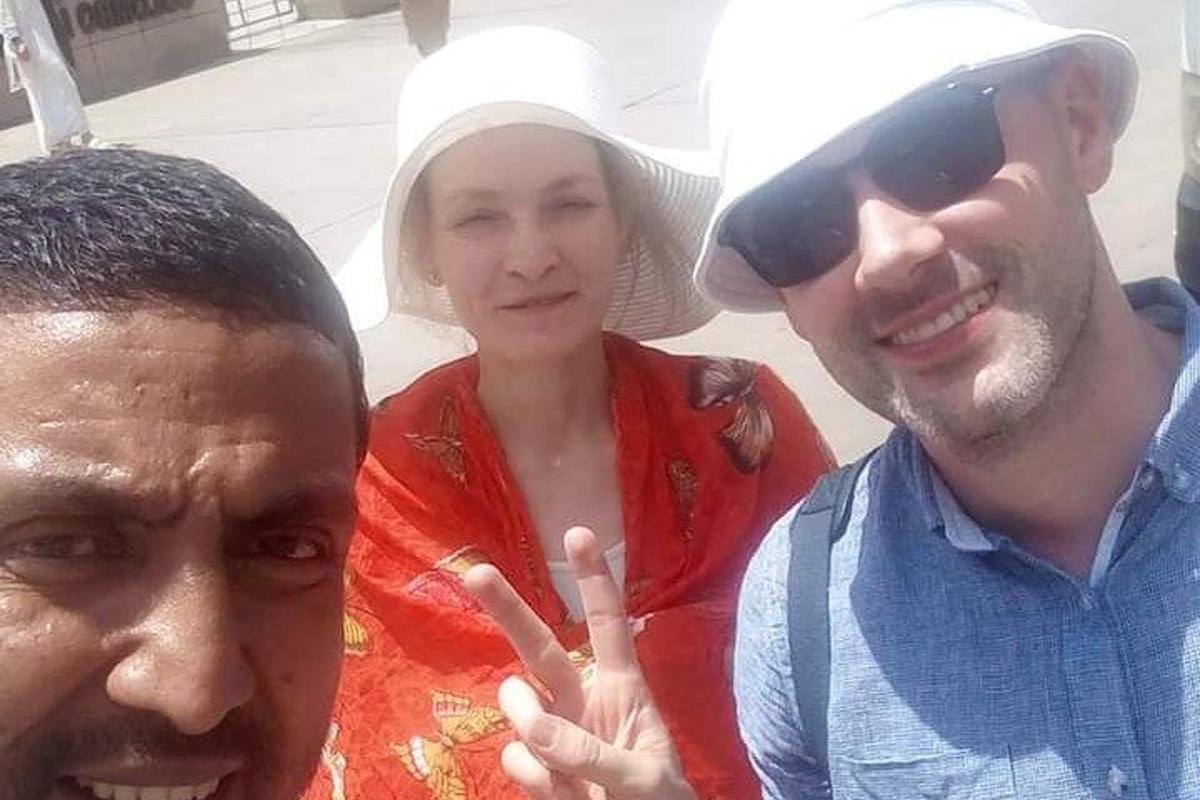 Dos hombres y una mujer posando para una fotografía