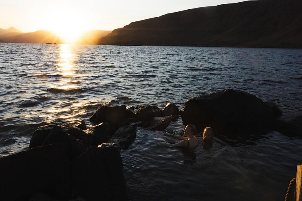 en gruppe mennesker som svømmer i vannet ved solnedgang