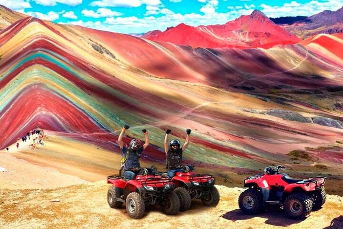 Két ember ATV-n egy hegyet ábrázoló festmény előtt