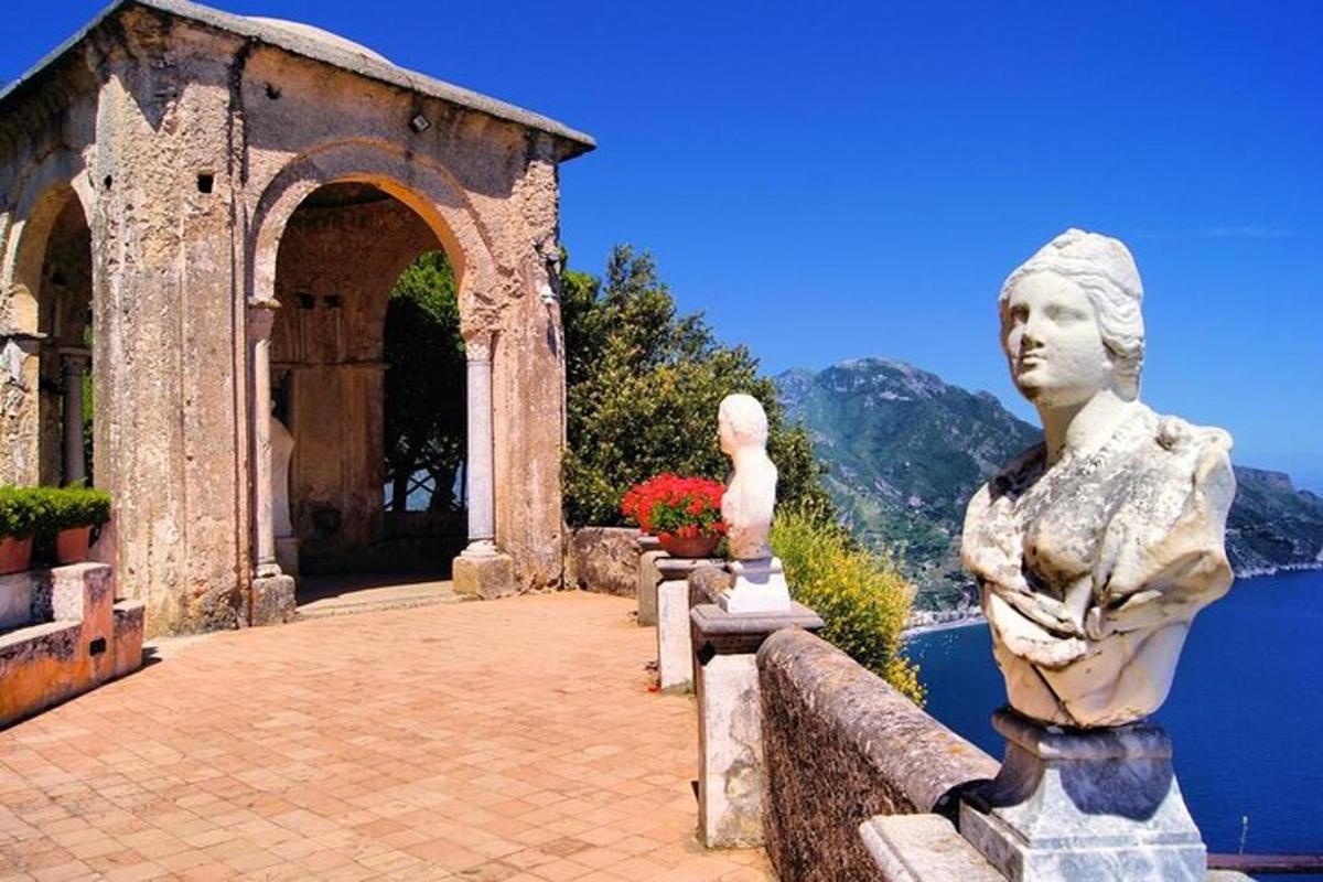 eine Statue einer Frau, die auf einer Bank in der Nähe des Wassers sitzt