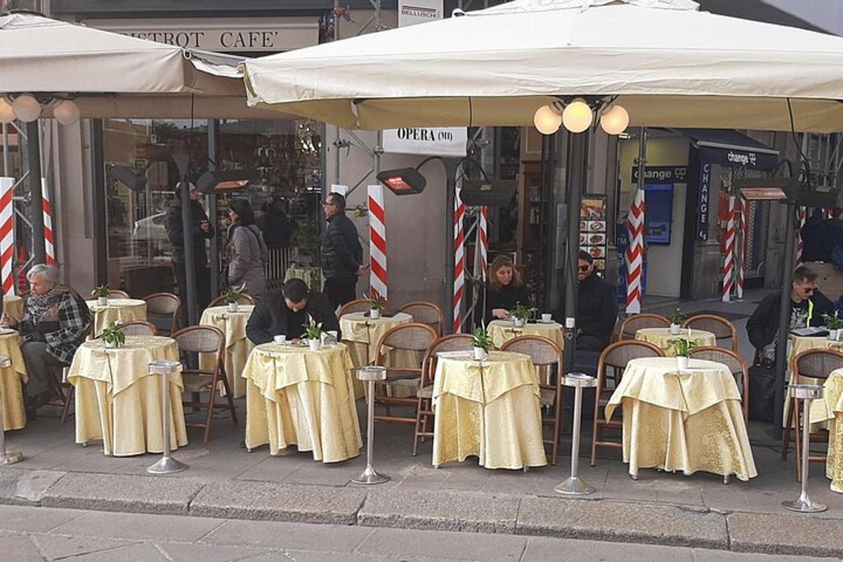 μια ομάδα από τραπέζια και καρέκλες κάτω από μια ομπρέλα