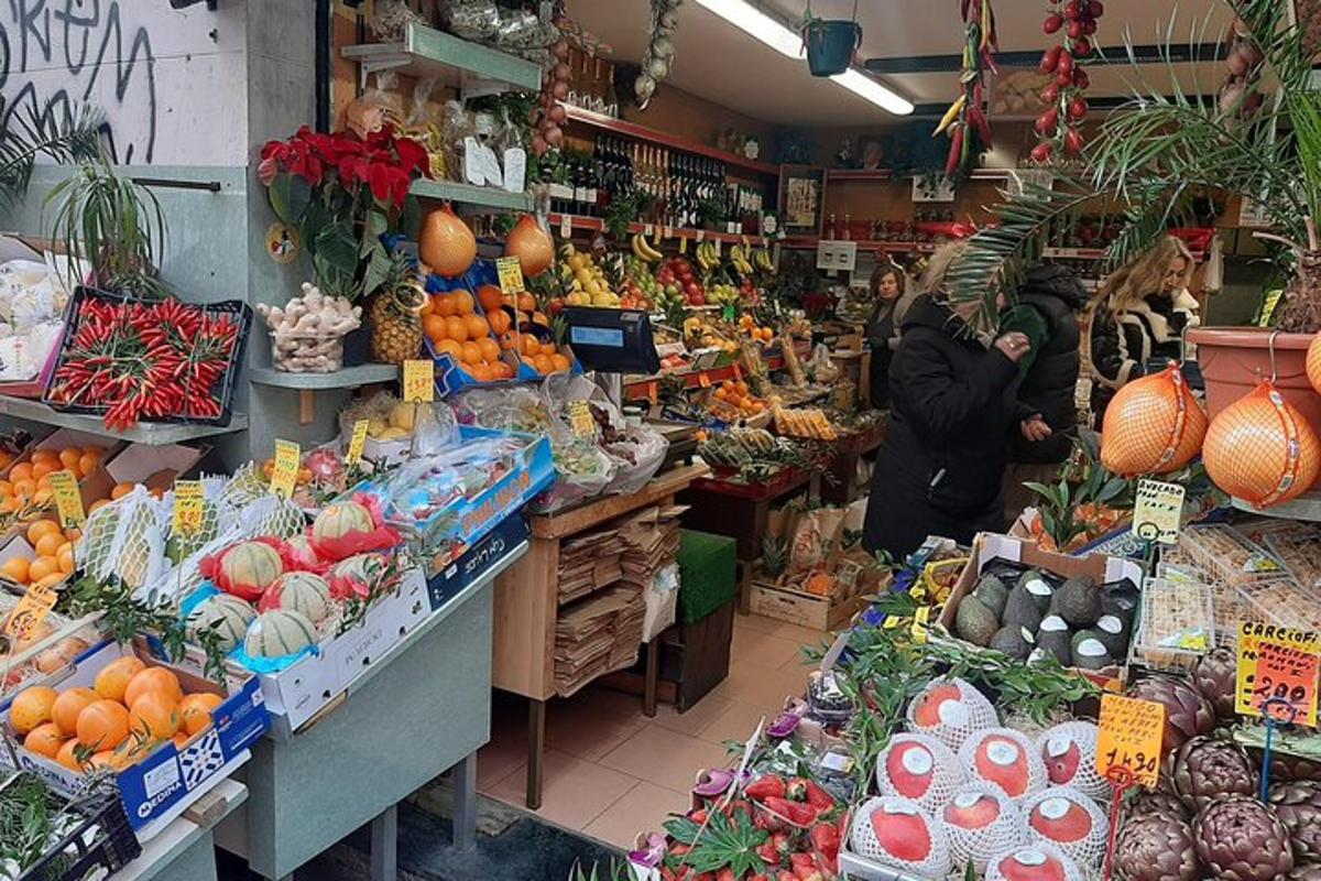 seorang wanita berdiri di pasar dengan buah-buahan dan sayur-sayuran