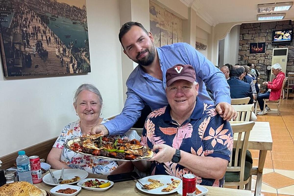 un bărbat și o femeie așezați la o masă cu o farfurie cu mâncare
