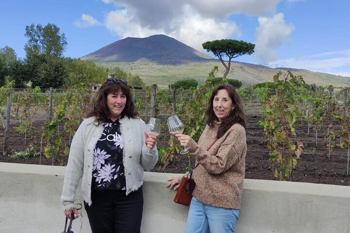 deux femmes debout à côté d'un mur tenant des verres à vin