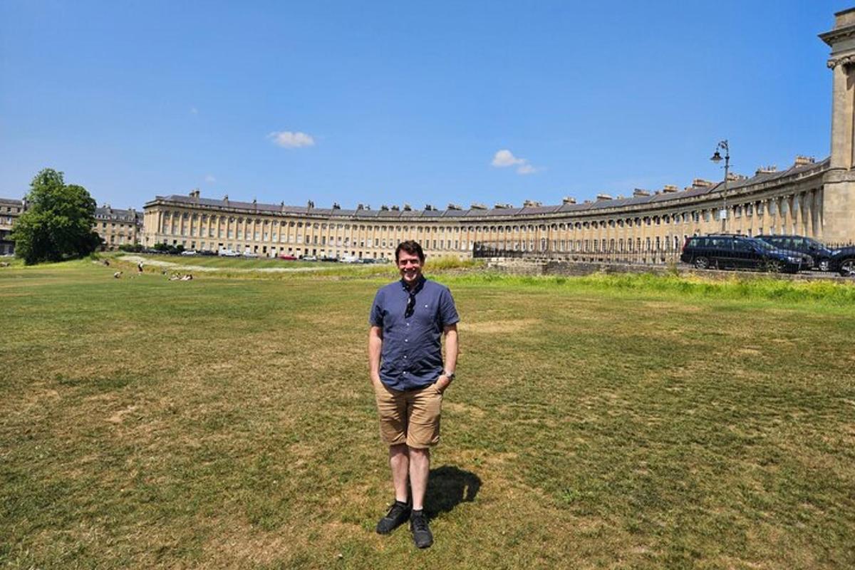 a man standing in a field in front of a building