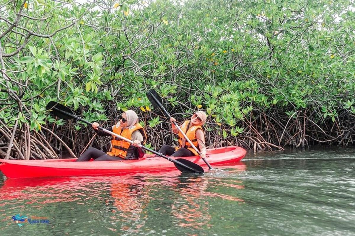 zwei Personen in einem roten Kajak auf einem Fluss