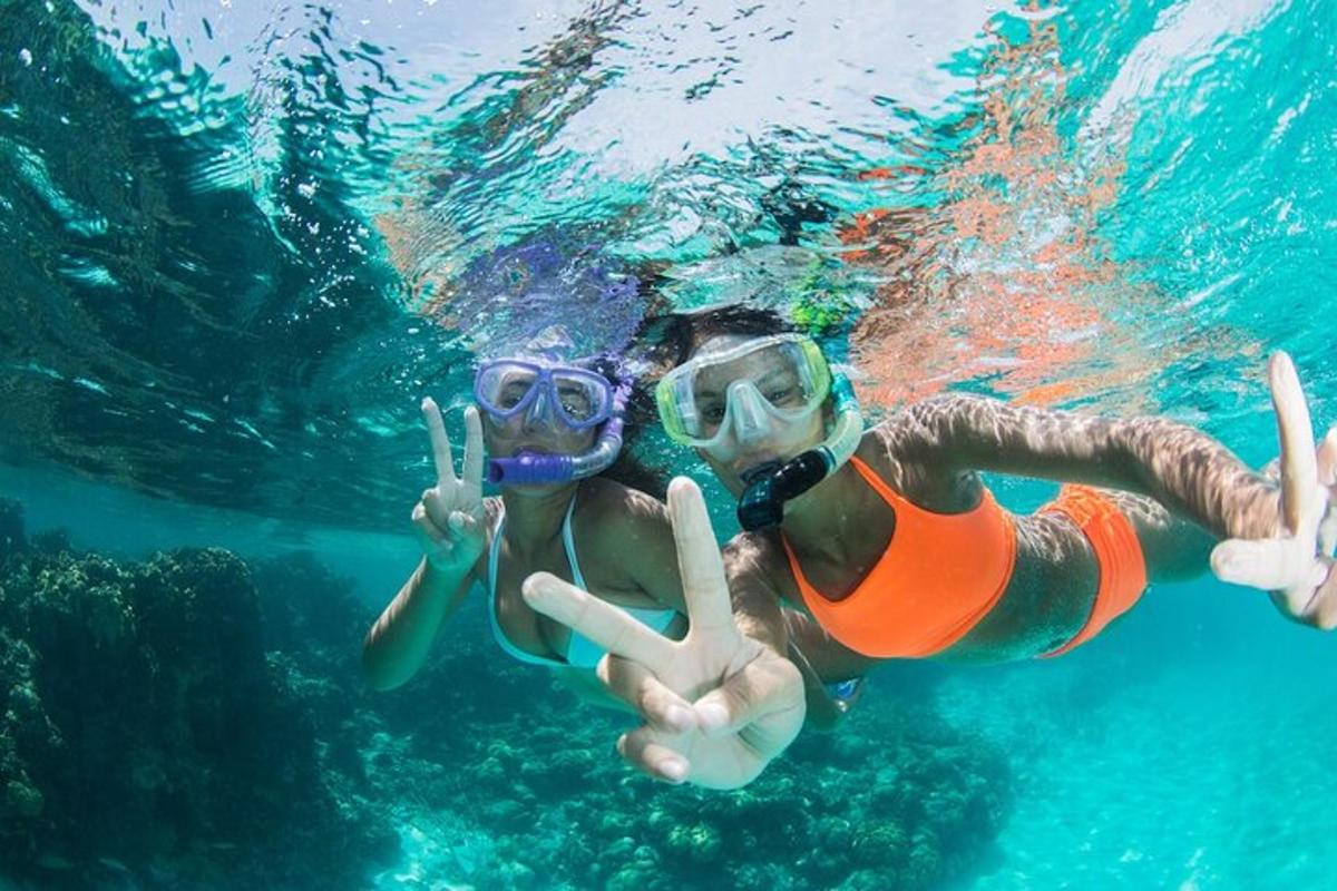 una donna in costume da bagno e occhialini è in acqua