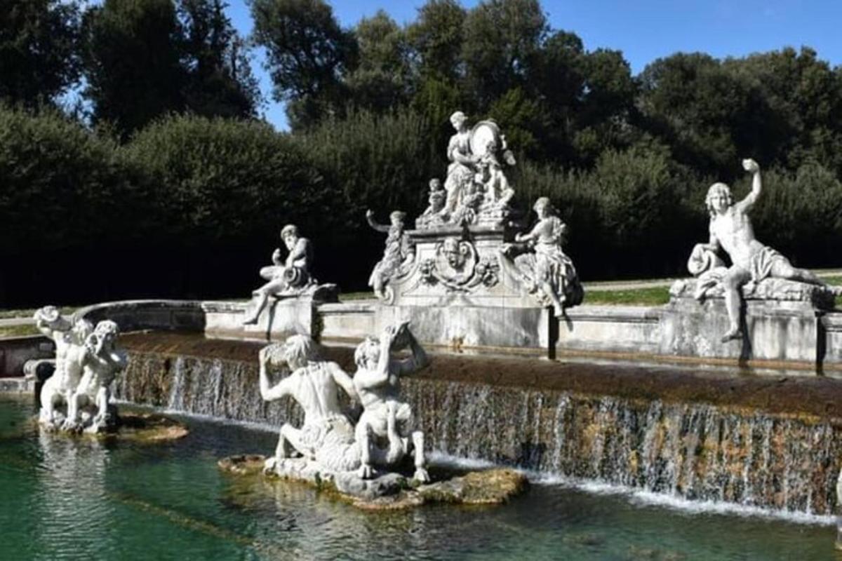 a fountain in a park with statues in the water