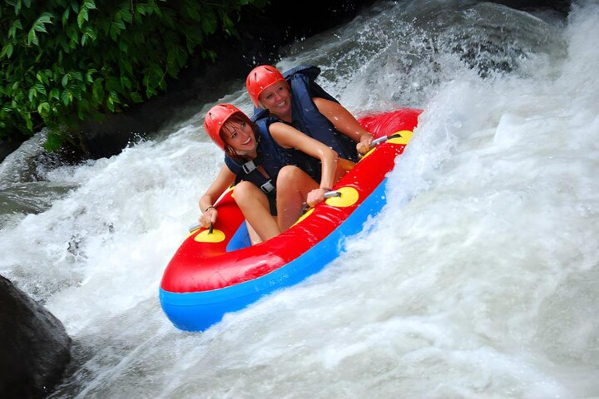 two people riding on a raft in a waterfall