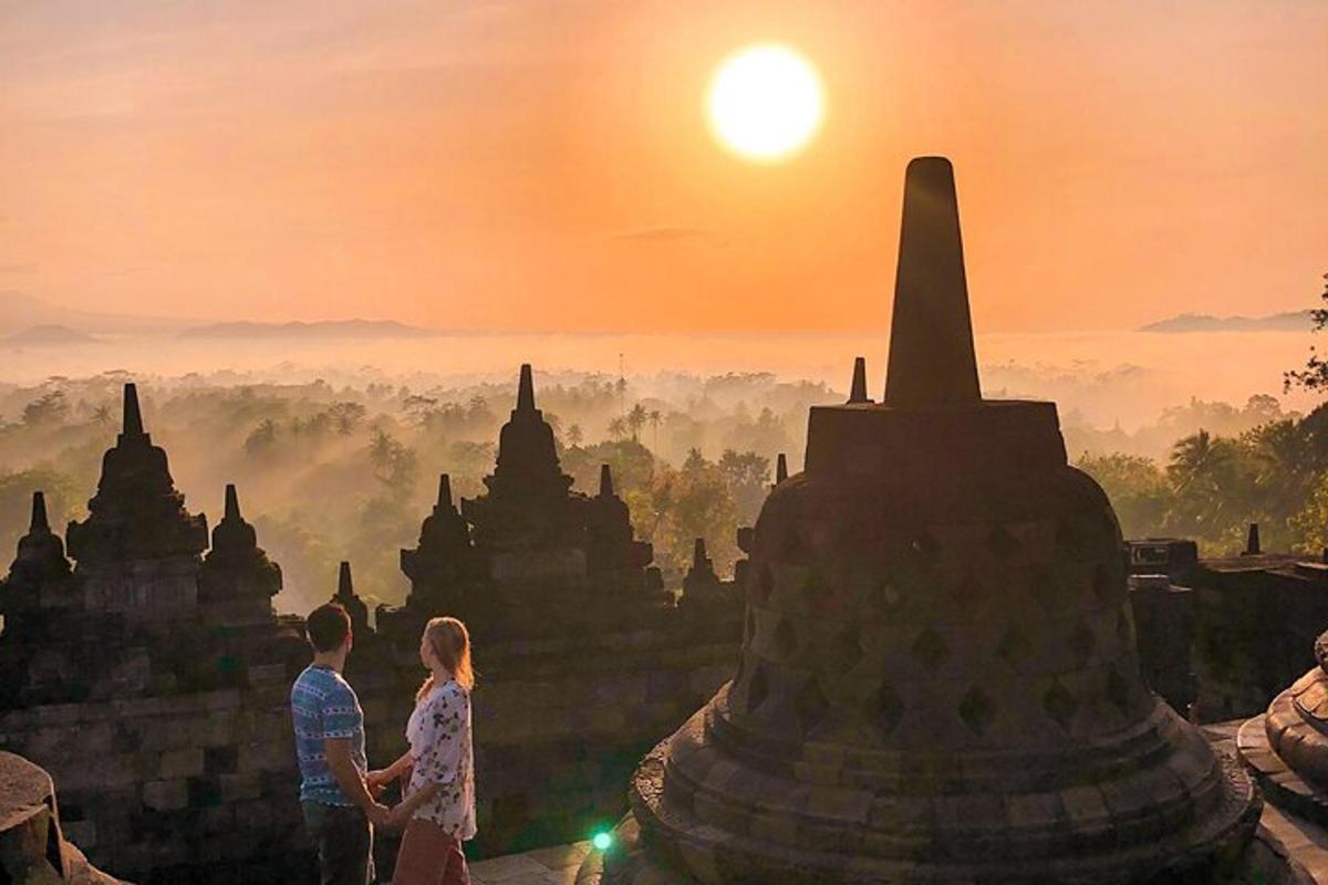 một cặp đôi đứng trước một ngôi đền lúc hoàng hôn