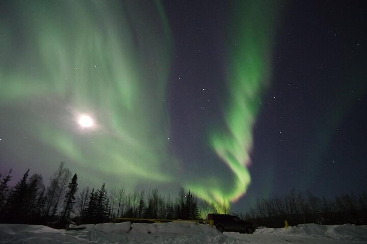 aurora na nebu s tovornjakom v snegu