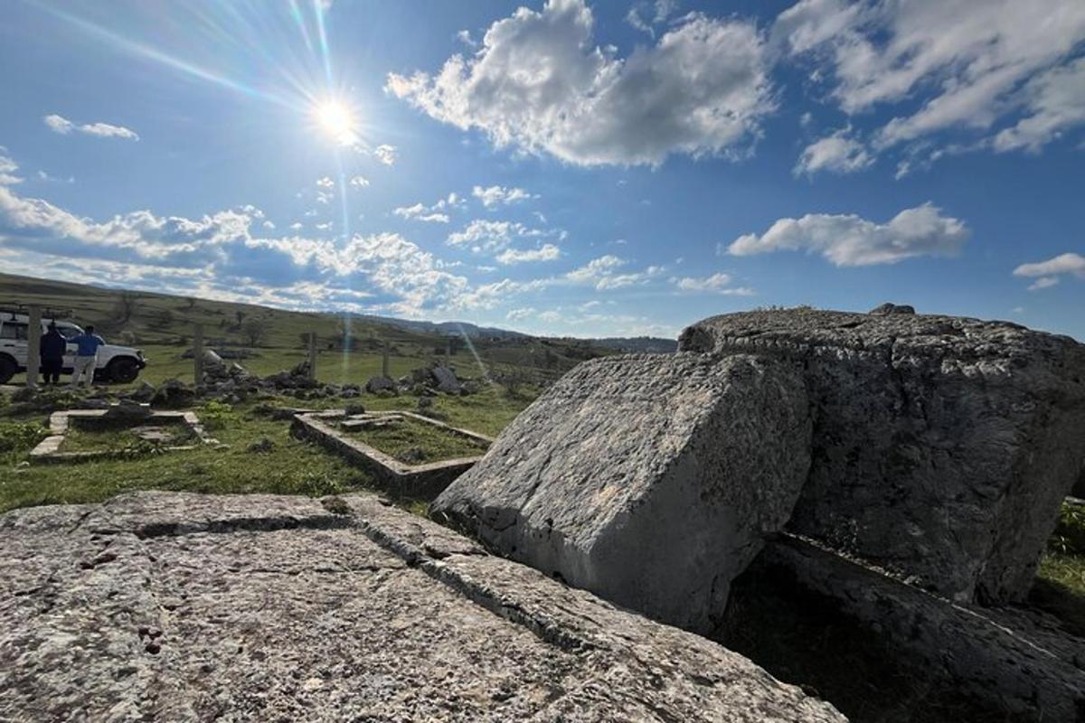 Un grupo de grandes rocas en un campo con el sol.