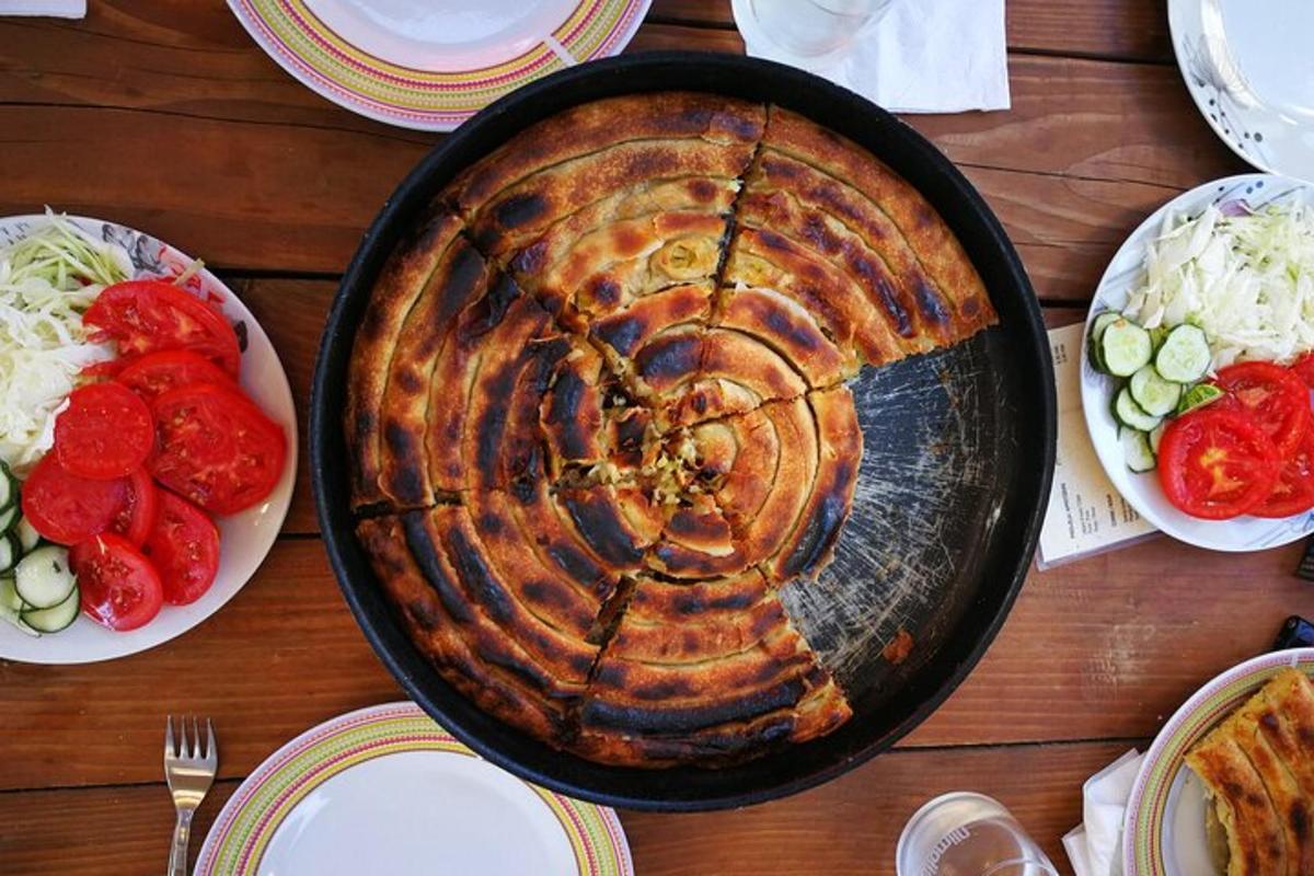 una torta in una padella su un tavolo con piatti di cibo