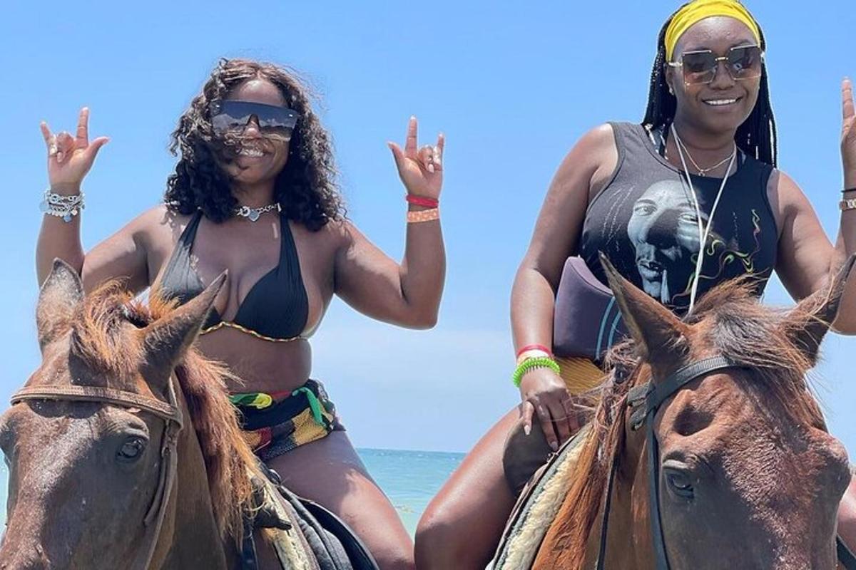 Két bikinis nő lovagol a tengerparton