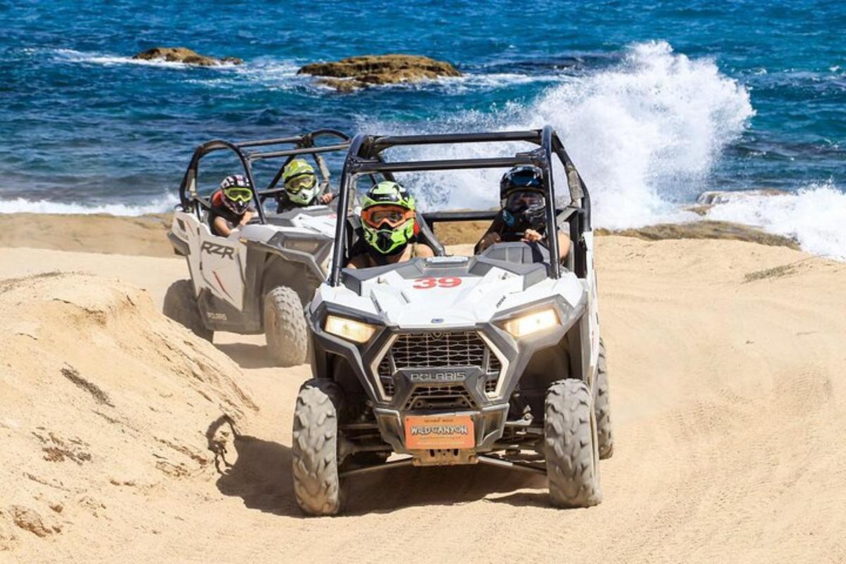 tre persone in quad sulla spiaggia