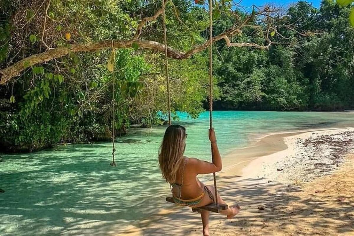 ženska v bikiniju sedi na gugalnici na plaži