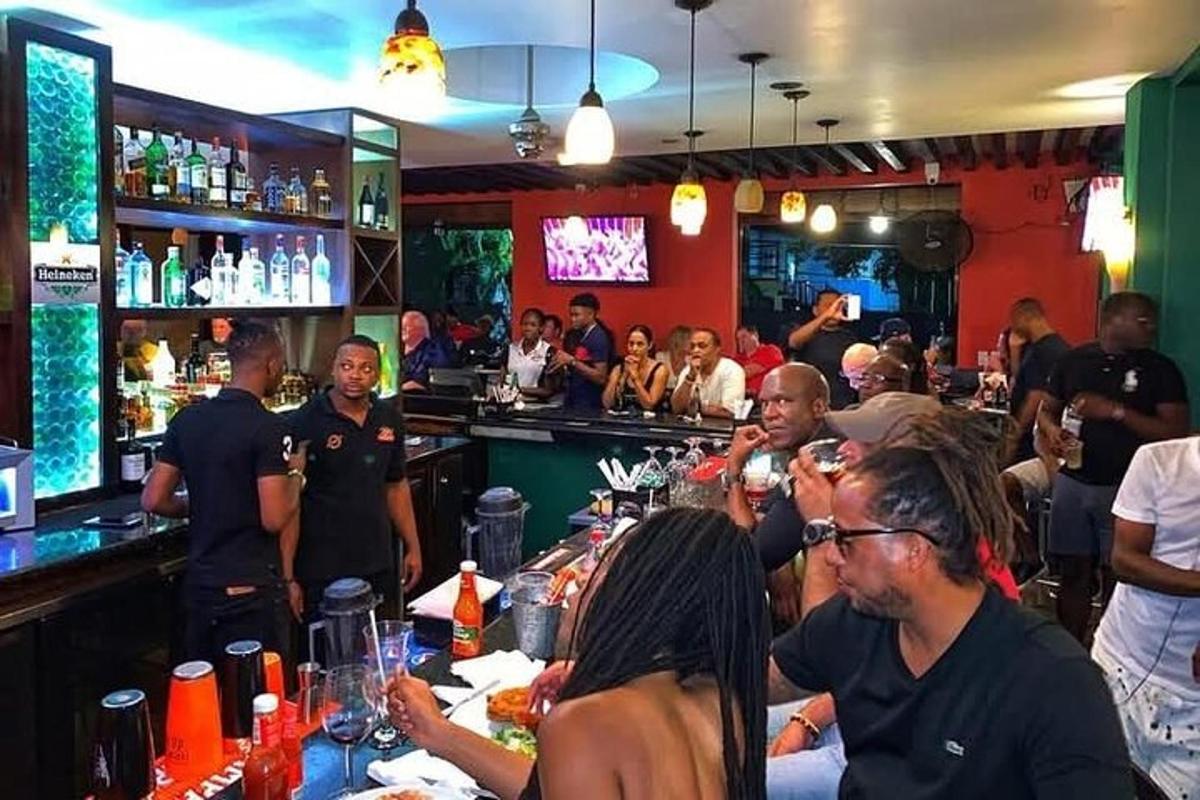 sekelompok orang yang sedang duduk di bar