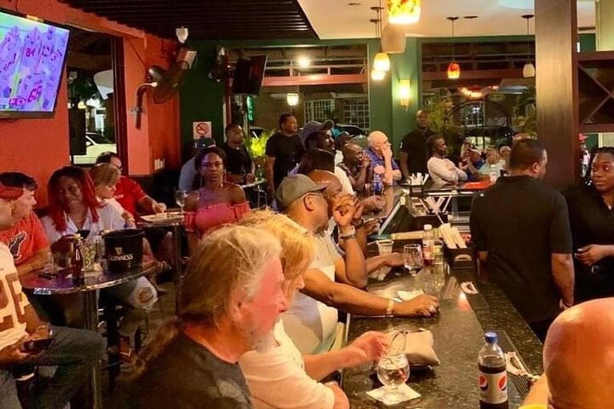 skupina ljudi, ki sedijo za barom v restavraciji
