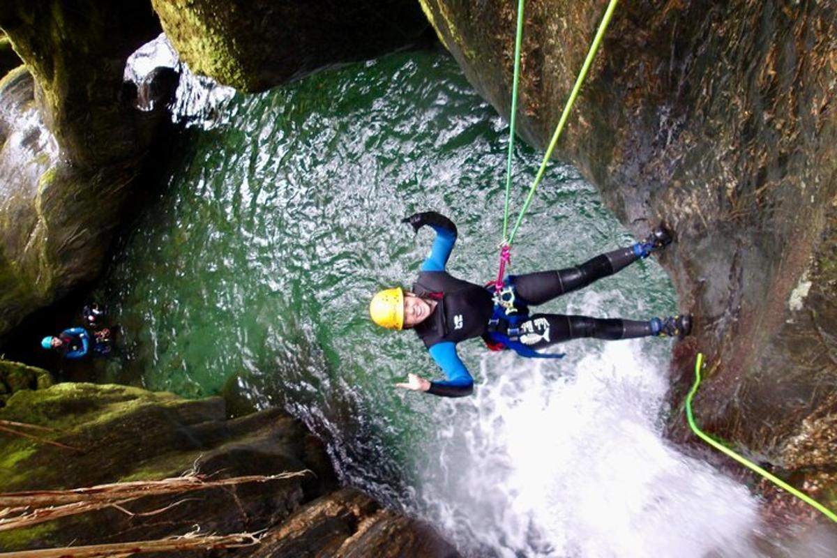 a man is rappelling down a waterfall in a river