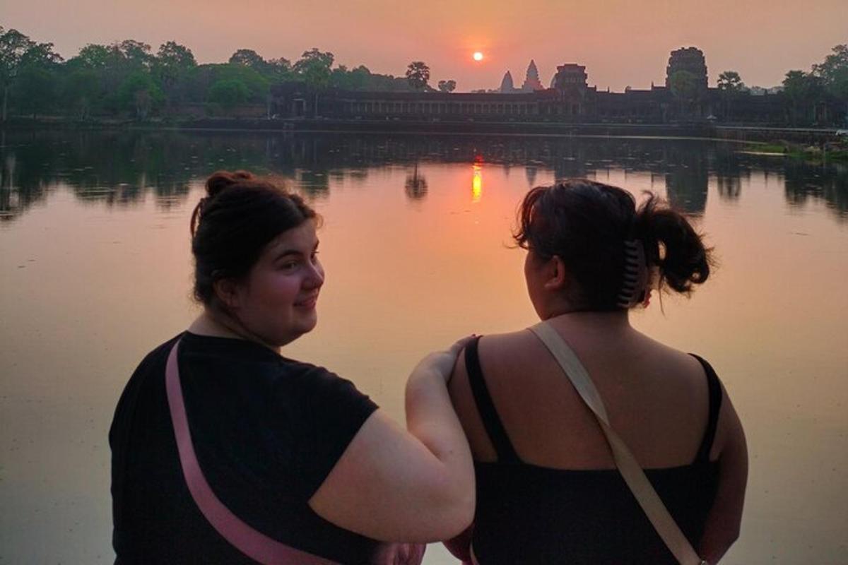due donne in piedi davanti a uno specchio d'acqua
