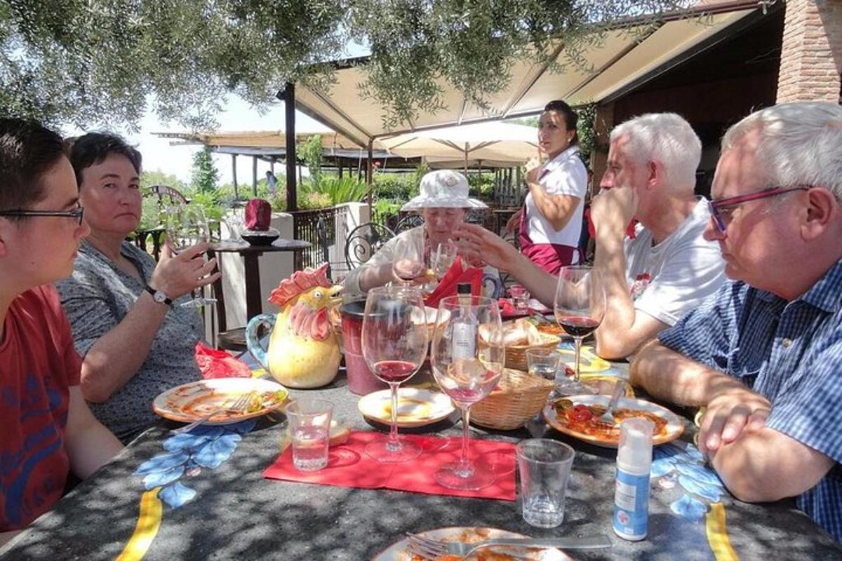 un grup de persones assegudes al voltant d'una taula amb copes de vi