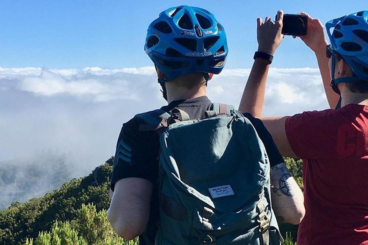 Dos personas con cascos tomando una fotografía de una montaña