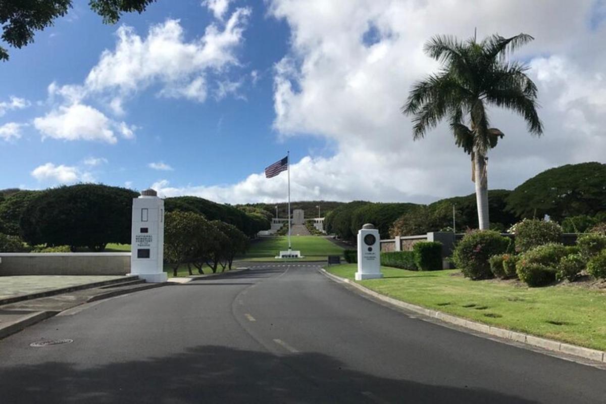 an empty road with a palm tree and a flag