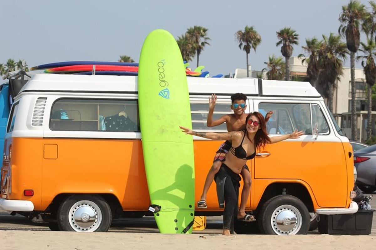 un uomo e una donna in piedi accanto a una tavola da surf