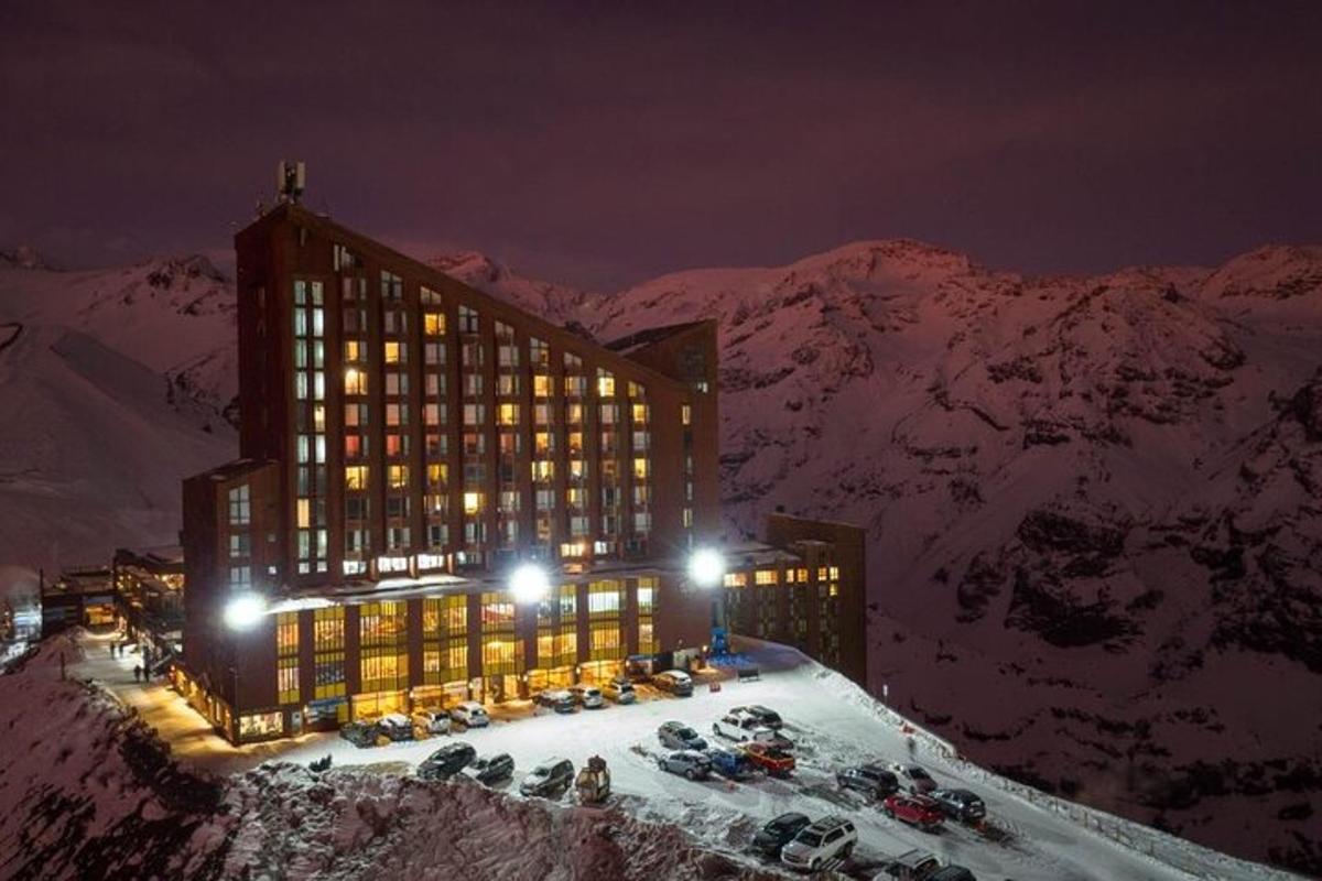 um edifício no topo de uma montanha coberta de neve à noite