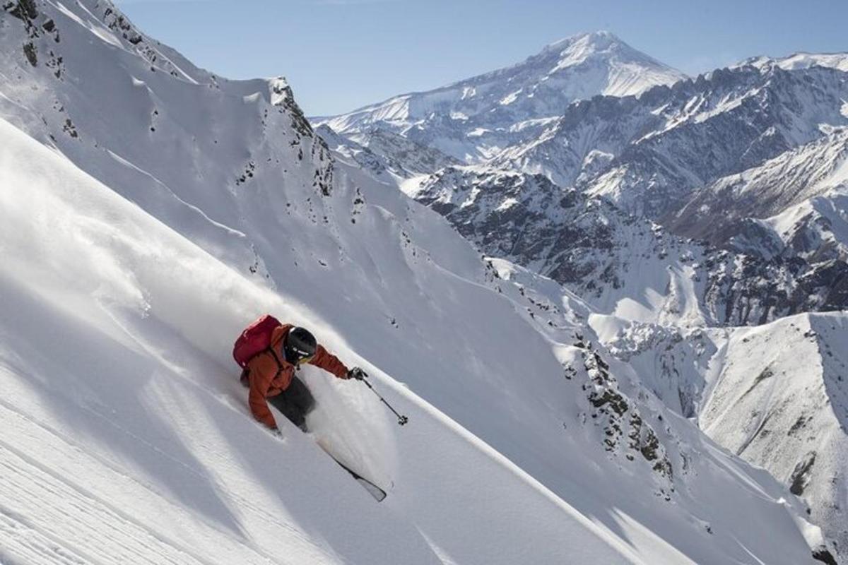 uma pessoa está esquiando montanha abaixo coberta de neve