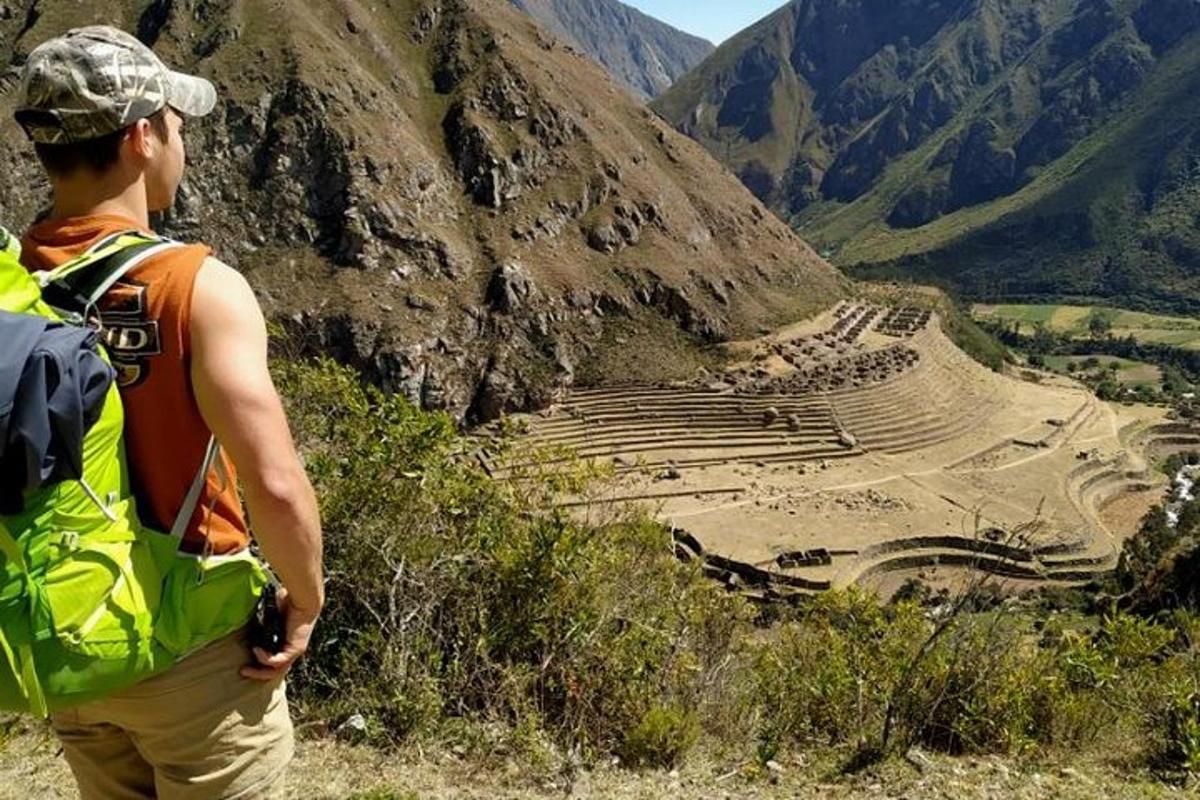 seorang pria berdiri di atas gunung sambil melihat amfiteater