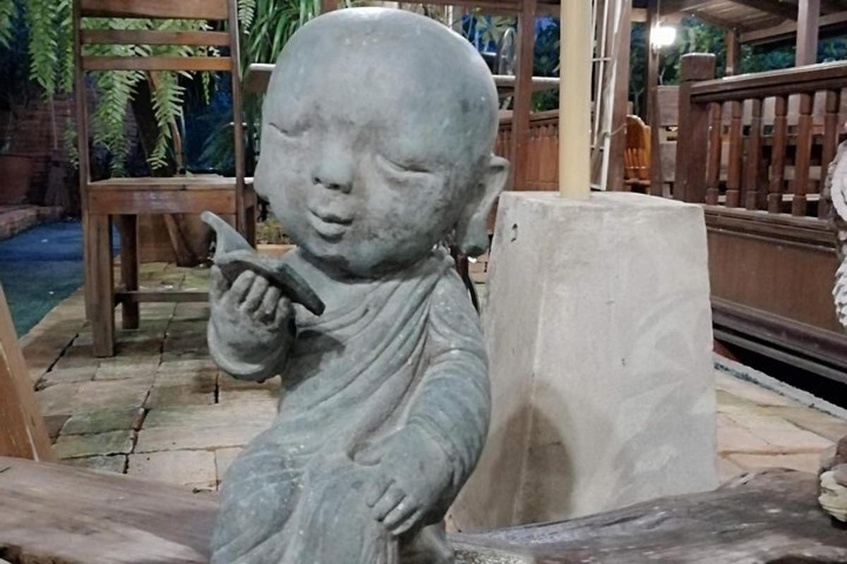 uma estátua de um garotinho segurando um telefone