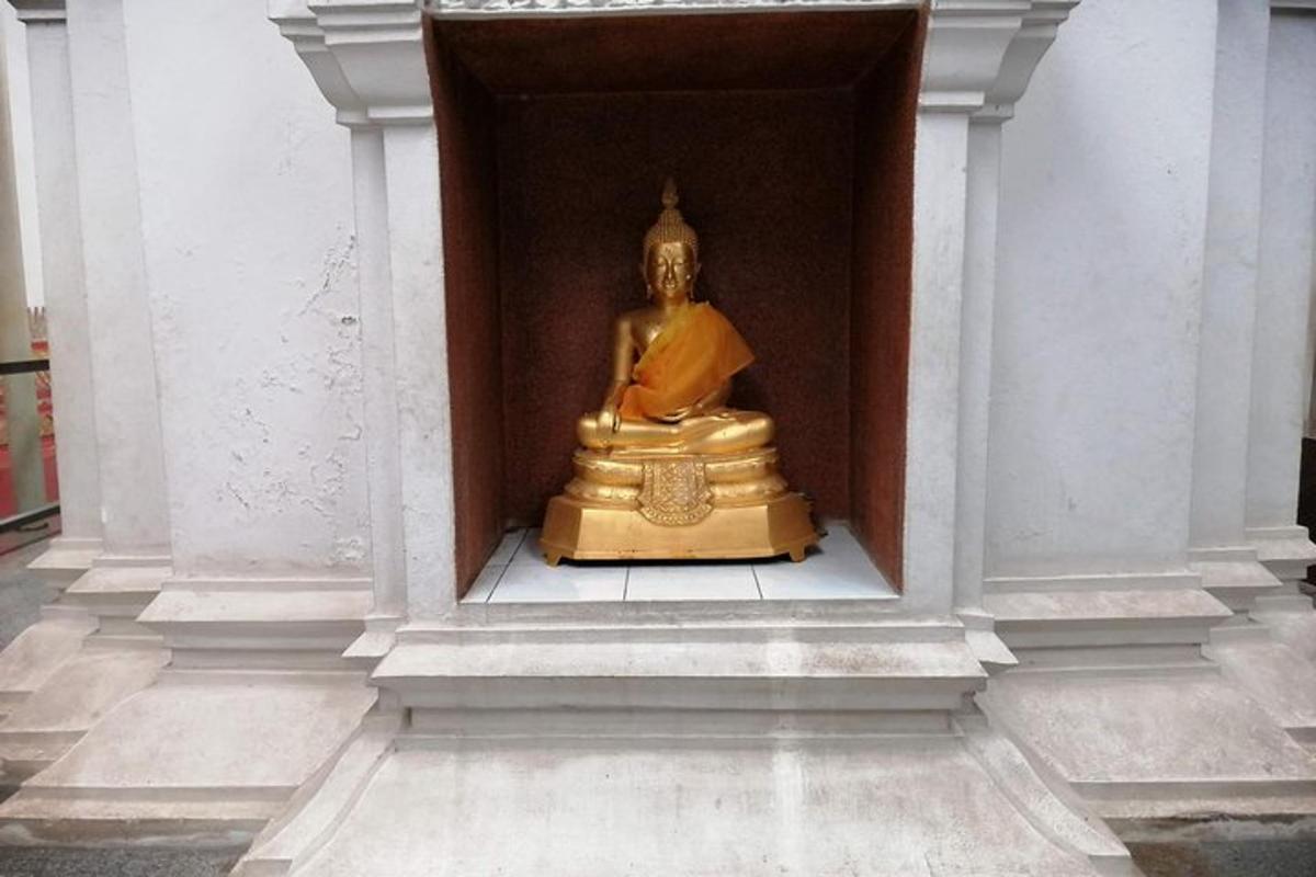 uma estátua de ouro sentada em um nicho de um edifício