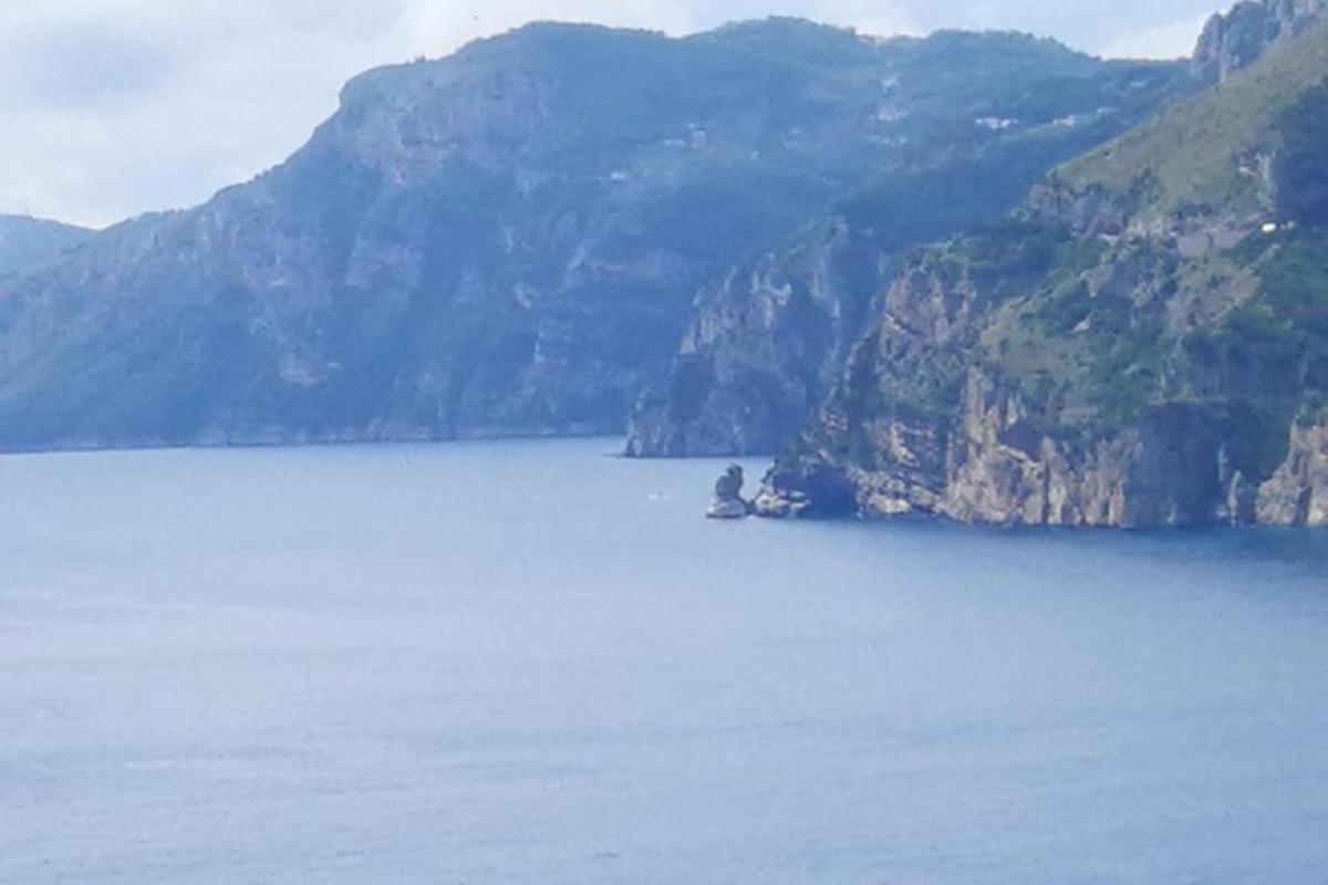 una persona seduta su una roccia in mezzo a un lago