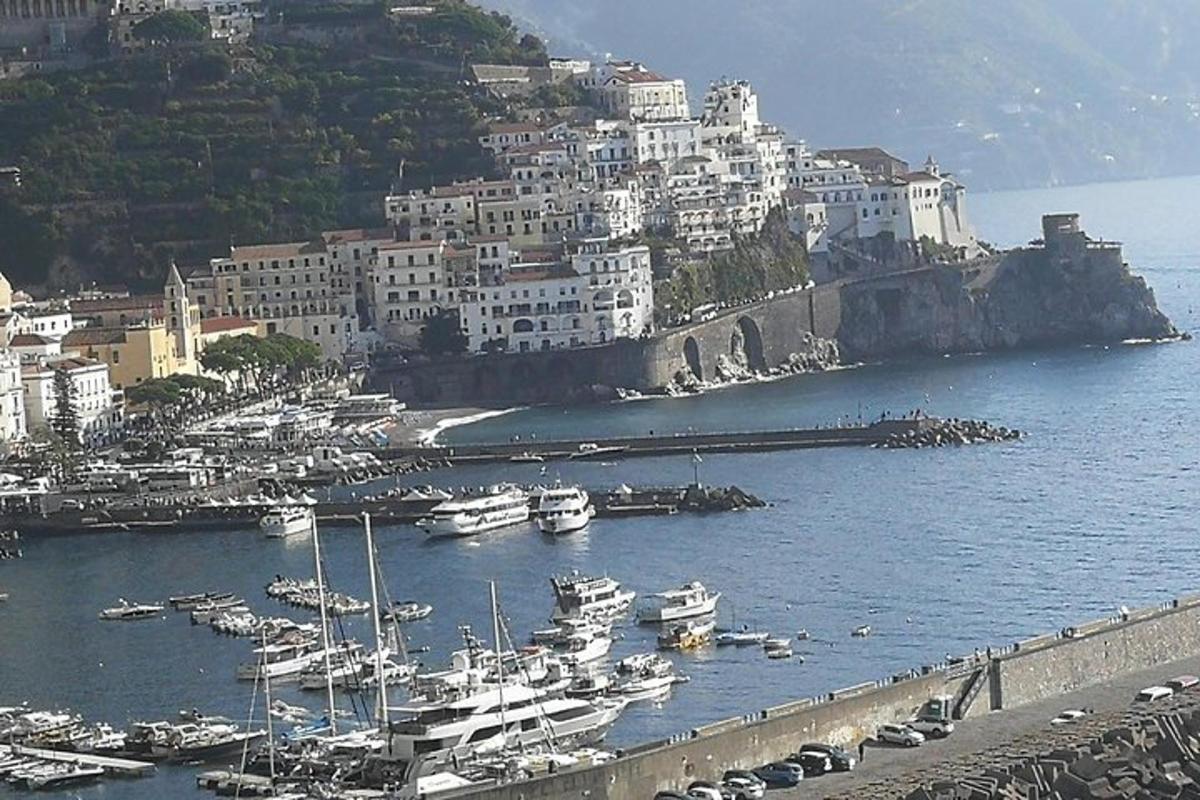 un gruppo di barche in un porto con una città