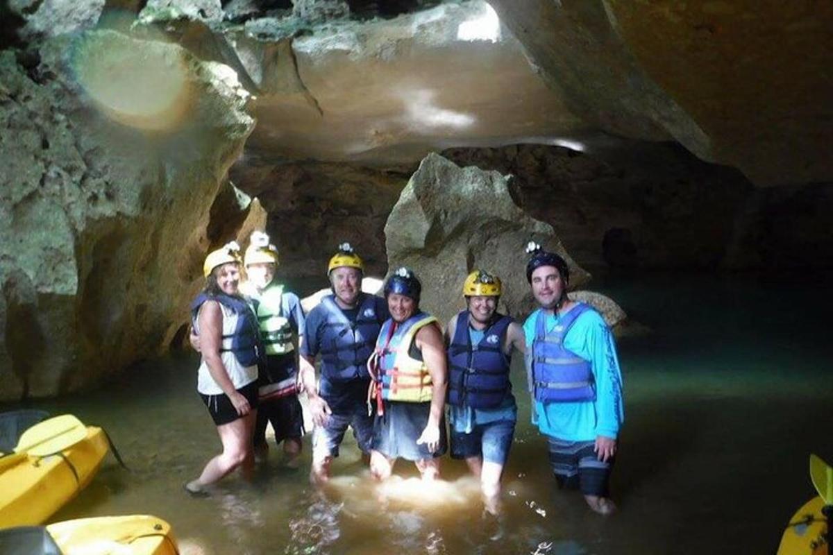 a group of people standing in the water in a cave