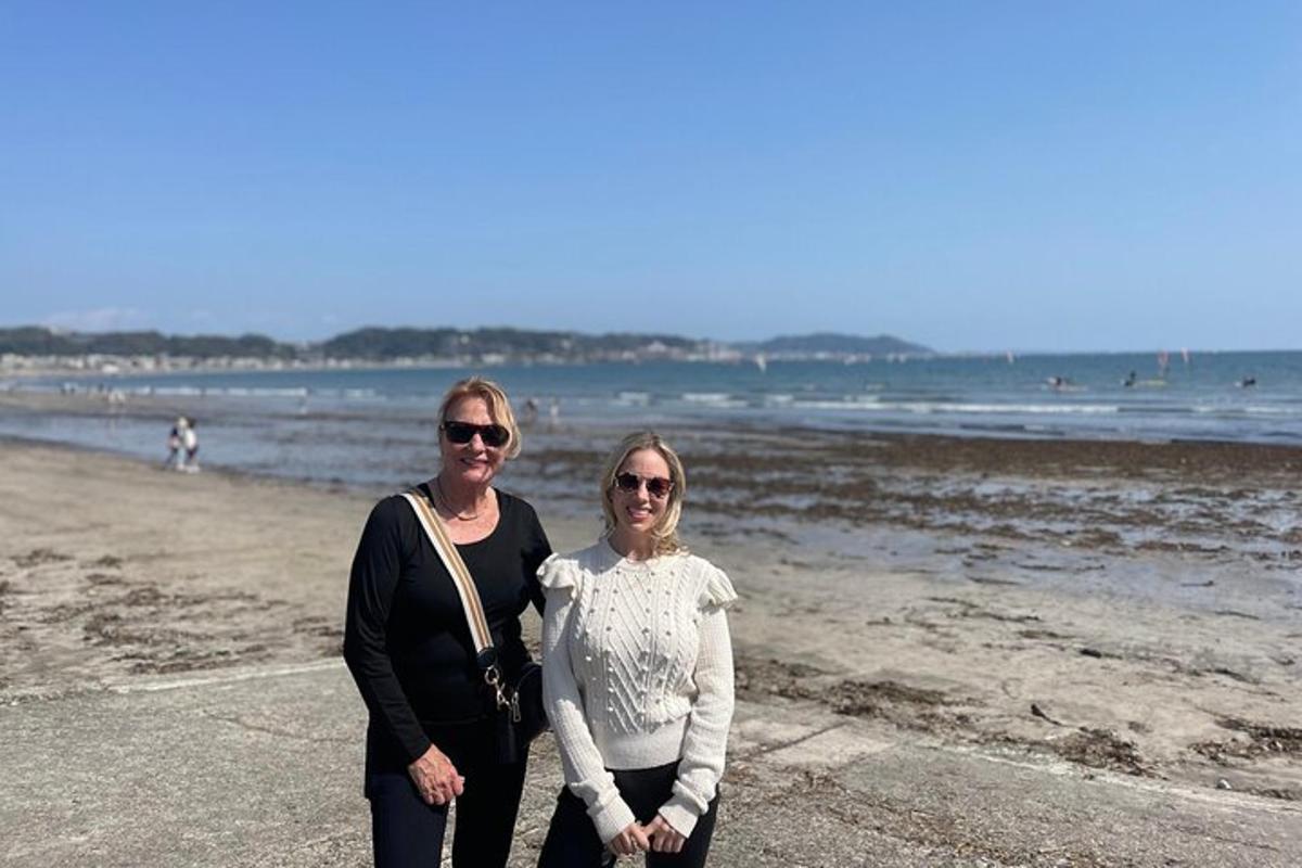 Dos mujeres de pie en la playa cerca del agua