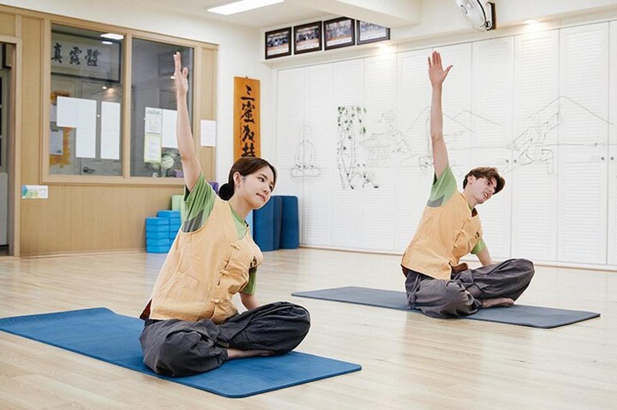 en mann og en kvinne som sitter på gulvet og gjør yoga